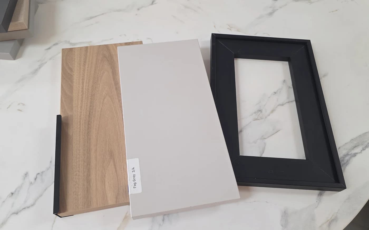 Cabinet door, wood and metal finish samples arranged together