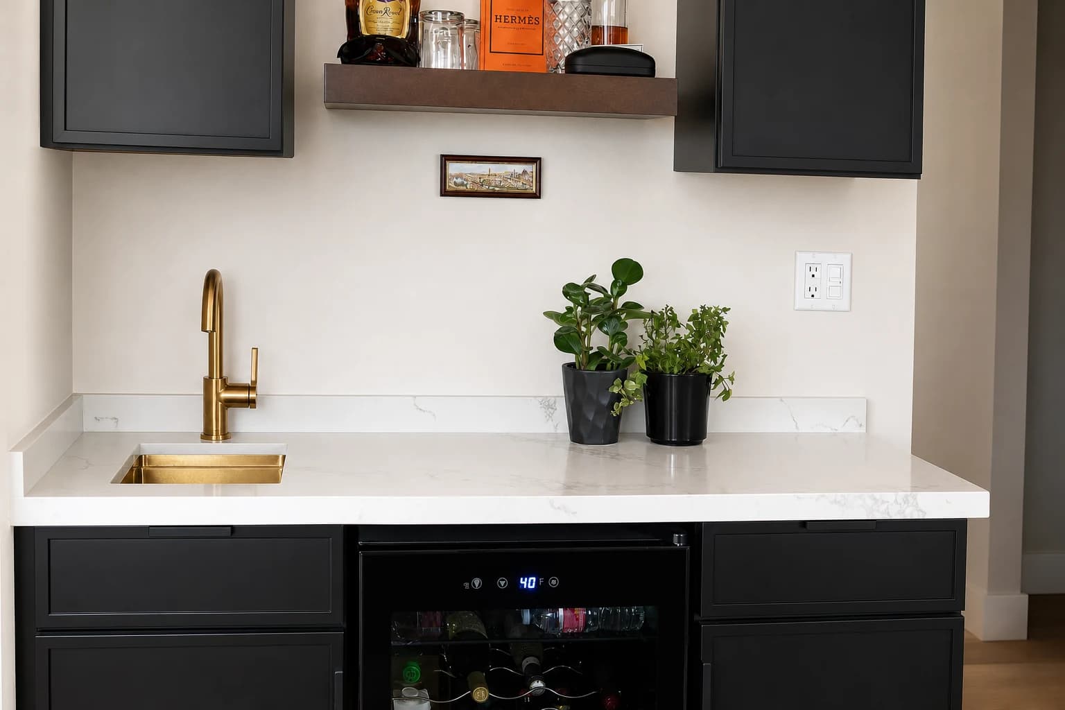 Completed wet bar with black cabinetry, brass sink, white stone counter, and beverage refrigerator
