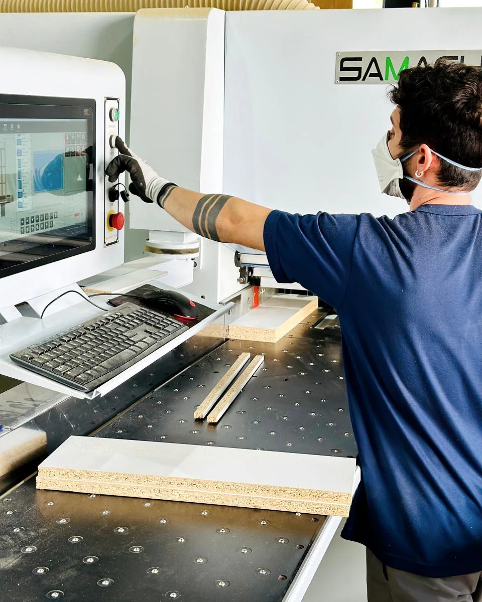Operator overseeing a CNC machining center cutting cabinet components