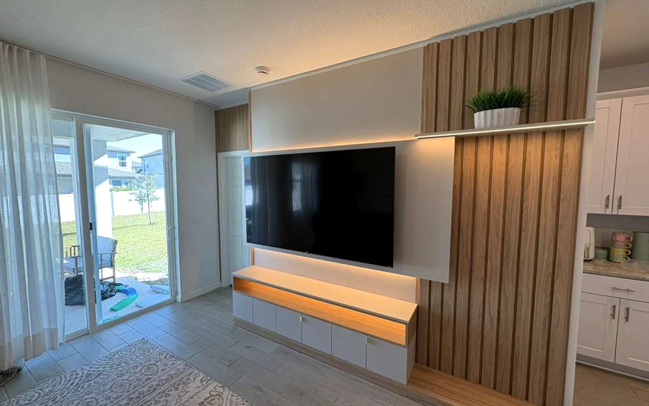 Warm oak media wall with concealed storage and integrated lighting