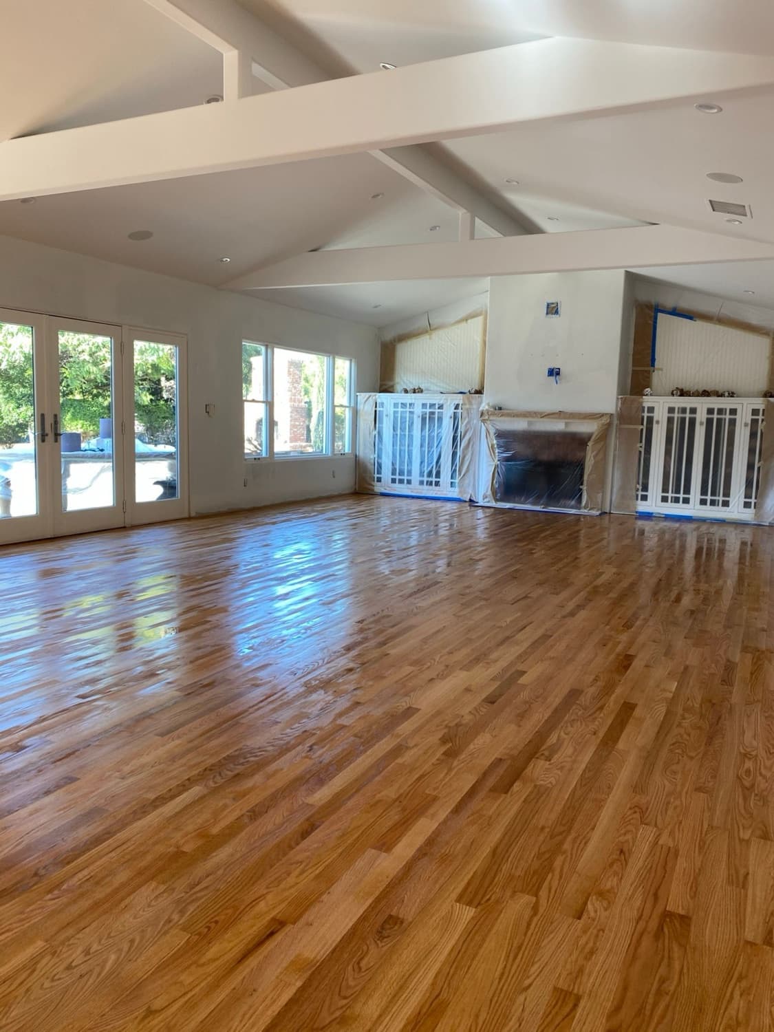 The same great room with the finished oak floor reflecting the windows