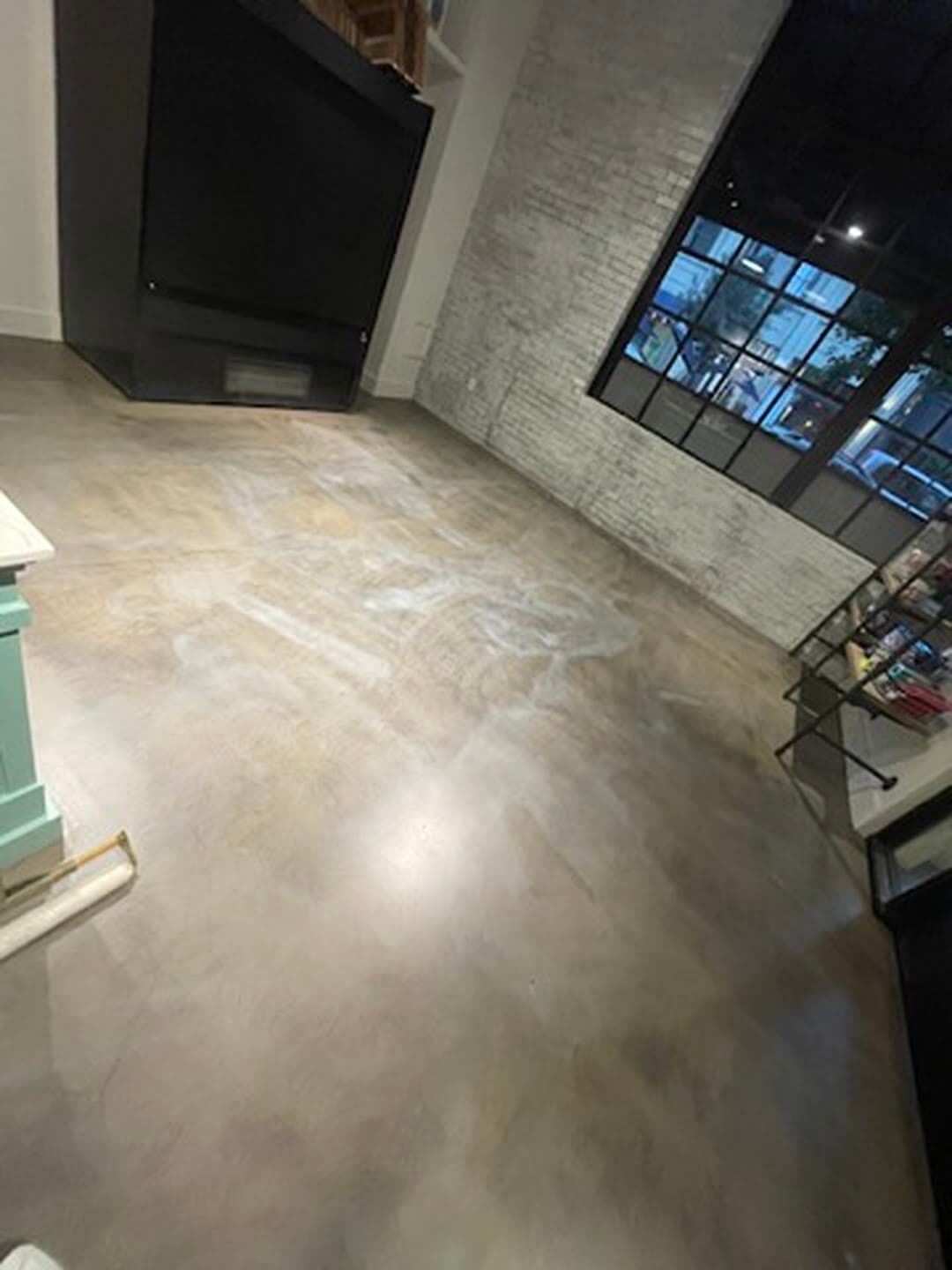 Bare concrete retail floor with marks and dust