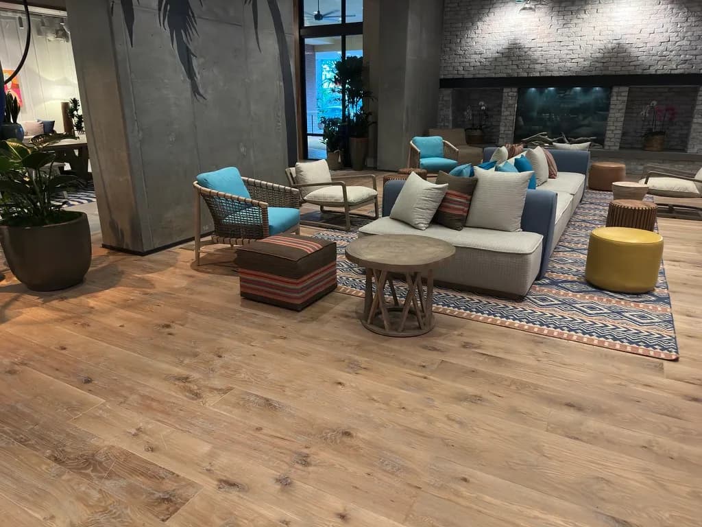 Wide plank wood floor finished through a furnished lobby, installed by Tidal Flooring