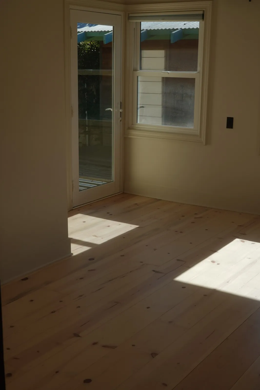 Wide pine floor finished in a sunlit bedroom