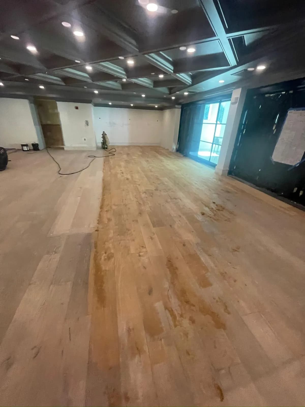 Stain samples applied across a sanded floor to choose the color