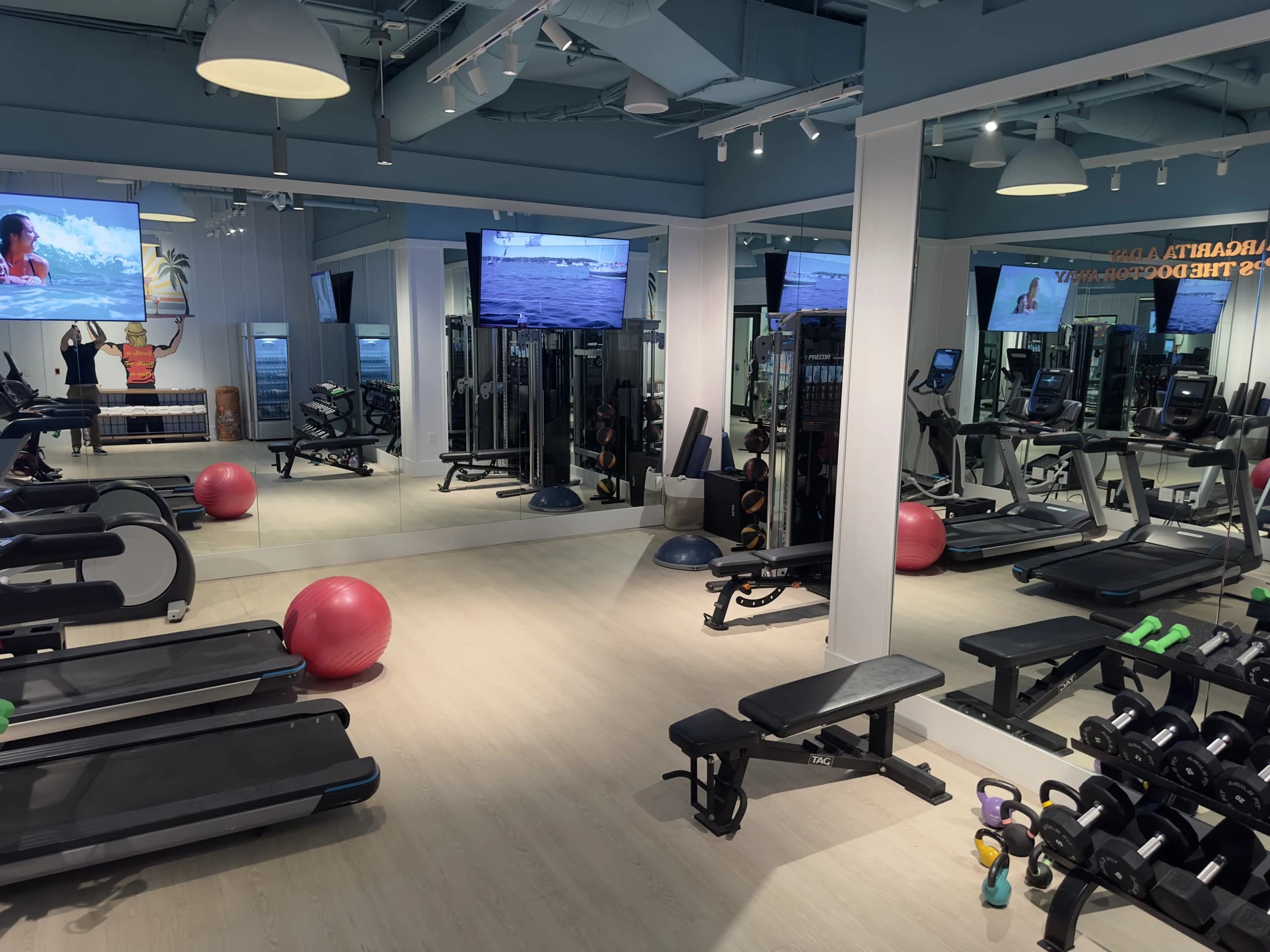 Completed commercial fitness room with mirrors, equipment, and lighting