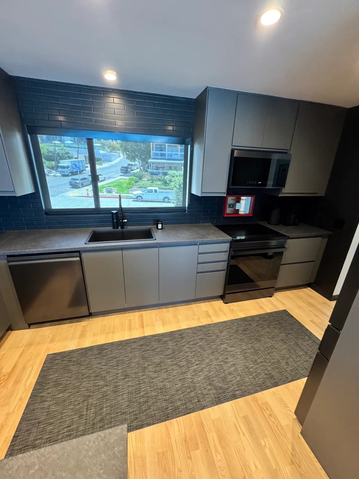 Charcoal kitchen wall with the sink under a wide window