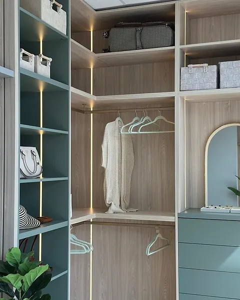 Corner wardrobe in sage green and light oak with hanging space and an arched mirror