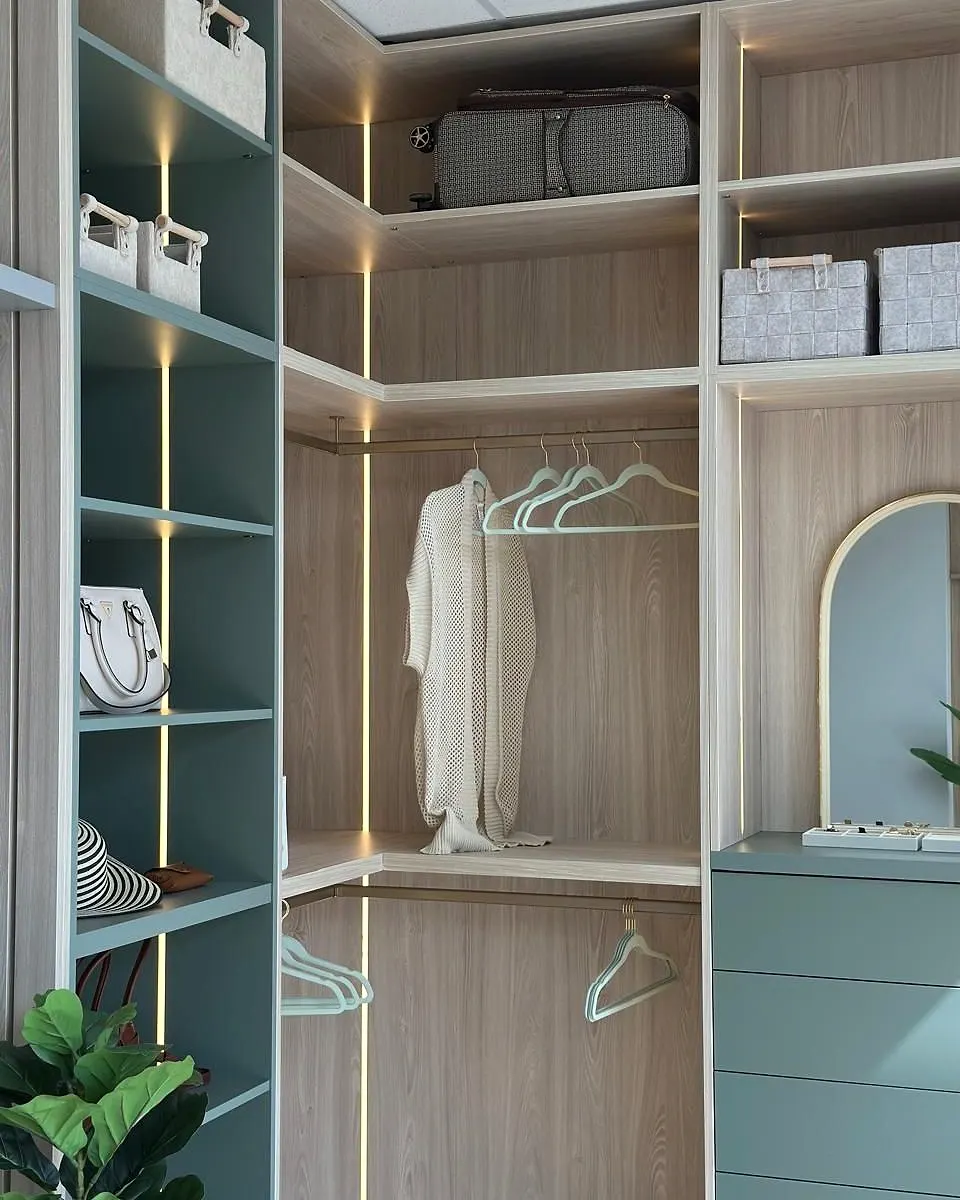 Corner wardrobe in sage green and light oak with hanging space and an arched mirror
