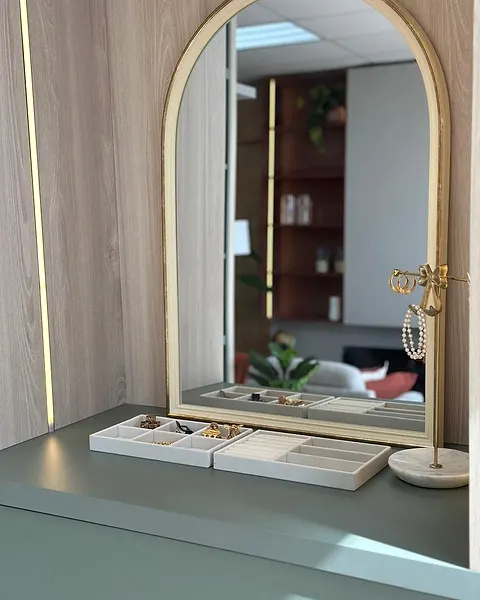 Built-in dressing table with an arched mirror framed by light oak panels