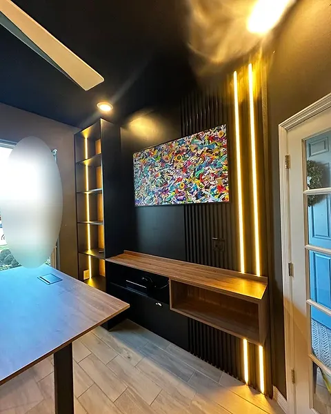 Office feature wall with vertical slats, light strips and a low wood shelf