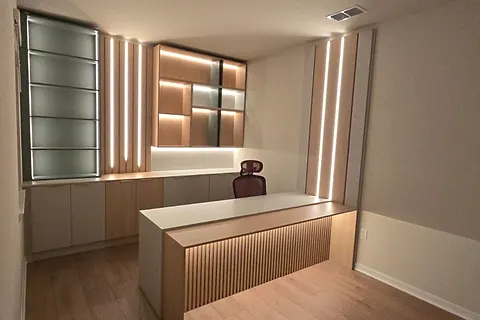 Office with a slatted wall panel, lit shelves and a central desk cabinet