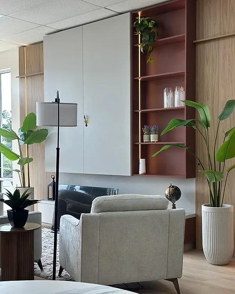 Showroom living wall with tall closed storage, a rust open shelf and an armchair