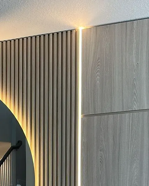 Close view of vertical wood-effect slats with a lit edge beside two wood-effect panel doors