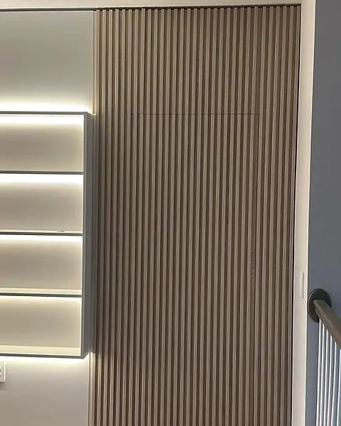 Close view of fine vertical wood-effect slats beside lit open shelves